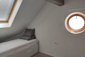 Cette petite chambre mansardée dispose d'une fenêtre et d'un lit. dans l'établissement Bovec Loft apartment, à Bovec