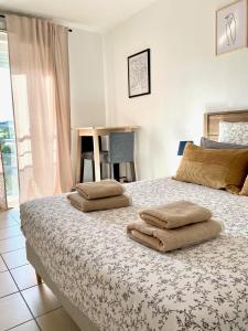 um quarto com uma cama com duas toalhas em Appartement en face Hopital Nord em Saint-Priest-en-Jarez