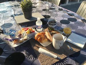 een tafel met een bord eten en een kopje koffie bij La Croisée Chambre d hôte avec sanitaires partagés in Guéreins