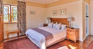 a bedroom with a large bed and a window at Knightsbury Guest House in Cape Town