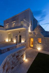 een groot stenen huis met verlichting in de tuin bij Terrazze Sulla Valle in Martina Franca