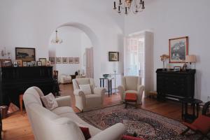 a living room with white furniture and a piano at Casa Do Lavre in Lavre