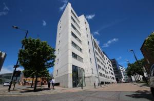 a tall white building on a city street at 1 Bedroom City Centre Apartment - Sleeps 4 Free Parking in Newcastle upon Tyne