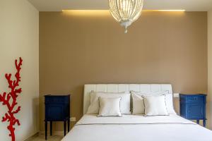 een slaapkamer met een wit bed en 2 blauwe nachtkastjes bij Suite Isavì in Giardini Naxos