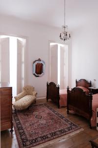 Habitación con 2 camas, silla y espejo. en Casa Do Lavre, en Lavre