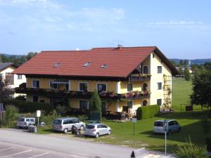 a large yellow house with a red roof at Ferien-Garconniere Hemetsberger in Weyregg