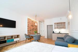 a living room with a couch and a table with chairs at Kopernika Apart in Toruń