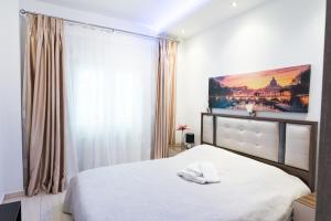 ein Schlafzimmer mit einem weißen Bett und einem großen Fenster in der Unterkunft Lassani cozy and quiet, 2 bedroom apartm with spacious balcony in Thessaloniki