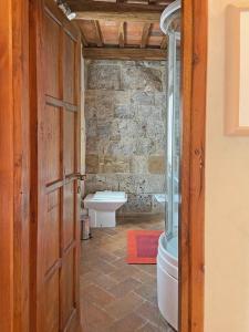 ein Bad mit einem WC, einem Fenster und einer Tür in der Unterkunft TWIN TOWER - unica al mondo - unique in the world in San Gimignano
