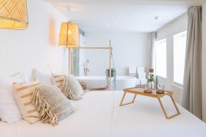 a white bedroom with a bed and a table at Op Oost Boutique hotel & Restaurant het Kook Atelier in Oosterend