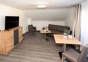 a living room with a couch and a flat screen tv at Hotel Lamm in Waiblingen