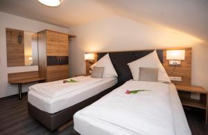 two beds in a hotel room with flowers on them at Hotel Lamm in Waiblingen