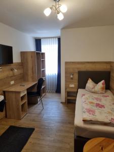 a room with a bed and a desk and a bed sidx sidx sidx at Landhotel Engel in Limbach