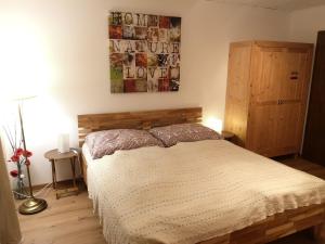 a bedroom with a bed and a picture on the wall at Ferien-Garconniere Hemetsberger in Weyregg