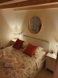 a bedroom with a bed with a mirror on the wall at La Casetta di Gloria in Lumbarda