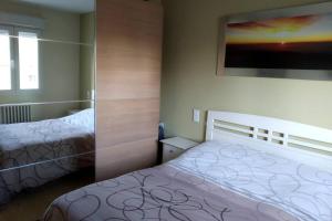 1 dormitorio con 2 camas y una foto en la pared en Cómodo, bien ubicado y 2 aparcamientos, en Zaragoza