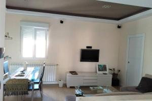 sala de estar con mesa y TV en la pared en Cómodo, bien ubicado y 2 aparcamientos, en Zaragoza