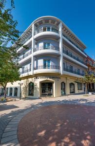 a large white building with a brick sidewalk in front of it at Hotel Hermes in Rhodes Town
