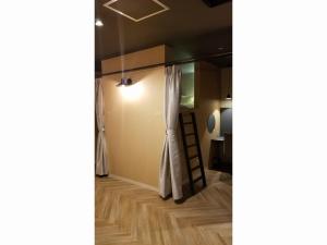 um quarto com uma cortina e um quarto com uma escada em Good Bless Garden Sauna&Stay em Yonago