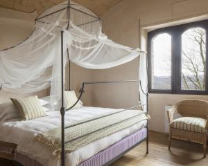 - une chambre avec un lit à baldaquin et une fenêtre dans l'établissement Castello di Gabiano, à Gabiano