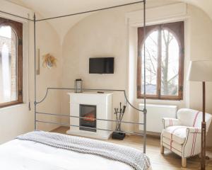 sypialnia z łóżkiem z baldachimem i kominkiem w obiekcie Castello di Gabiano w mieście Gabiano