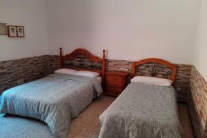 dos camas sentadas una al lado de la otra en un dormitorio en Casa Rural Los Cipreses. Cercados de Araña, en San Bartolomé