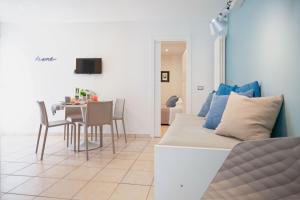 ein Wohnzimmer mit einem Sofa und einem Tisch mit Stühlen in der Unterkunft Residenza Alma in Riccione
