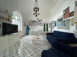 a living room with a blue couch and a tv at TERRAZZA Marina Piccola in Capri
