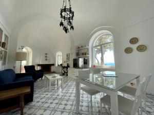 a kitchen and living room with a table and chairs at TERRAZZA Marina Piccola in Capri