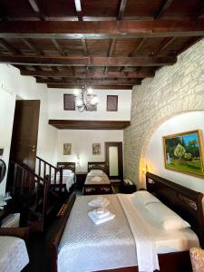 um quarto com três camas e uma parede de pedra em White House Berat em Berat
