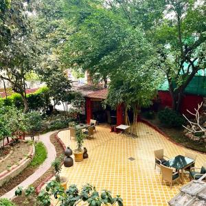 an outdoor patio with chairs and tables and trees at Ranjit's Svaasa Amritsar in Amritsar