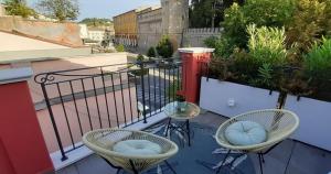 een balkon met 2 stoelen, een tafel en een hek bij LE ROSSI BED in Cesena
