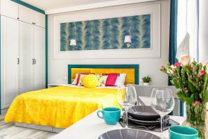 una camera da letto con un letto giallo e due bicchieri di vino di Apartament Turkusowy a Zamość