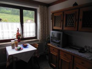 a kitchen with a table and a tv and a table and a window at Ferienhaus Moser in Bad Gastein