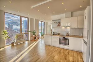 eine große Küche mit weißen Schränken und einem großen Fenster in der Unterkunft OpaKopa in Klaipėda