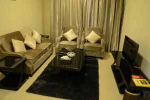 a living room with two chairs and a tv at Reef Hotel Aparts (Tabasum Group) in Ajman 