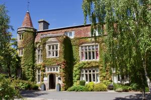 an old house with ivy on the side of it at Glyndley Manor Cottages in Polegate