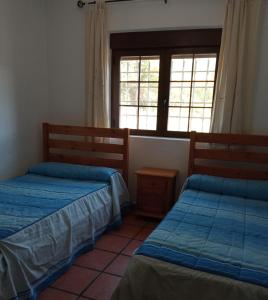 2 camas en una habitación con ventana en Casas Rurales Campolibre, en Masegoso