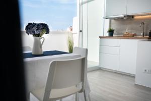 a white kitchen with a vase of flowers on a table at Vico Blu in Polignano a Mare