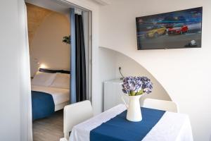 a room with a table with a vase of flowers on it at Vico Blu in Polignano a Mare