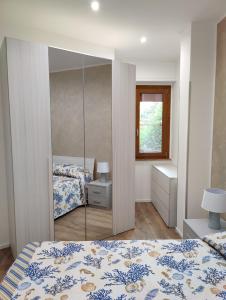 una camera con letto e specchio di Appartamento Maraviglios Alghero ad Alghero