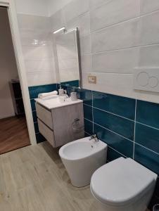 bagno con servizi igienici bianchi e lavandino di Appartamento Maraviglios Alghero ad Alghero