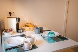 a table with plates and cups and a coffee maker at Vico Blu in Polignano a Mare