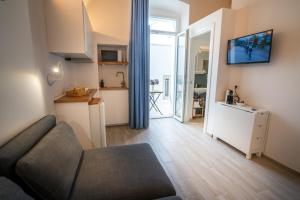 a living room with a couch and a kitchen at Vico Blu in Polignano a Mare