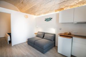 a living room with a couch in a kitchen at Vico Blu in Polignano a Mare