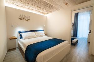 a bedroom with a large bed with blue sheets at Vico Blu in Polignano a Mare