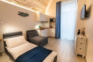 a bedroom with a bed and a chair at Vico Blu in Polignano a Mare
