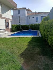 a swimming pool in a yard next to a house at Villa Leon in Reisdere