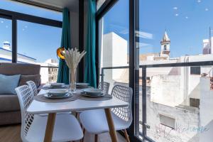 a white table and chairs in a room with a window at Apartamentos luxury Doña Bella 2a in Ayamonte