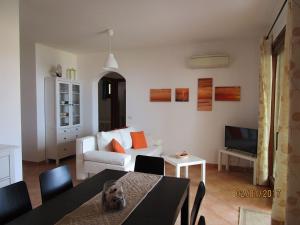 een woonkamer met een tafel en een bank bij Appartamento con vista meravigliosa in Castelsardo